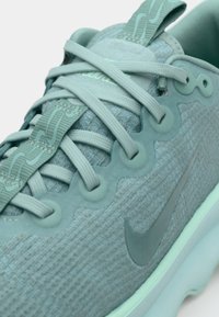 Svijetloplave atletske tenisice s teksturiranom tkaninom, zaobljenim detaljima i istaknutim swoosh označavanjem. Imaju ravne vezice i podstavljeni ovratnik.