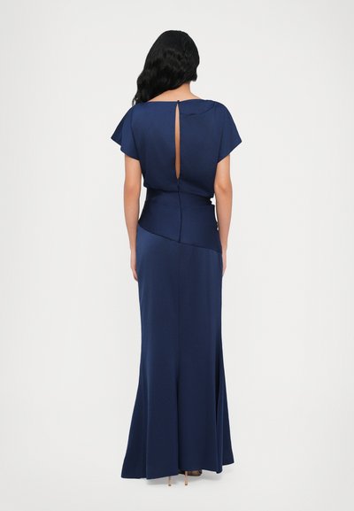 Navy blue evening gown with short flutter sleeves, low back slit, and a fitted waist. Smooth texture with a flowing skirt.