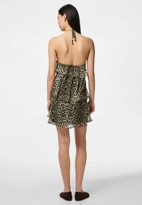 Vestido mini de tirantes con estampado de leopardo, con capas volantes, tejido ligero y espalda descubierta, que cuenta con lazos en el cuello para un ajuste ajustable.