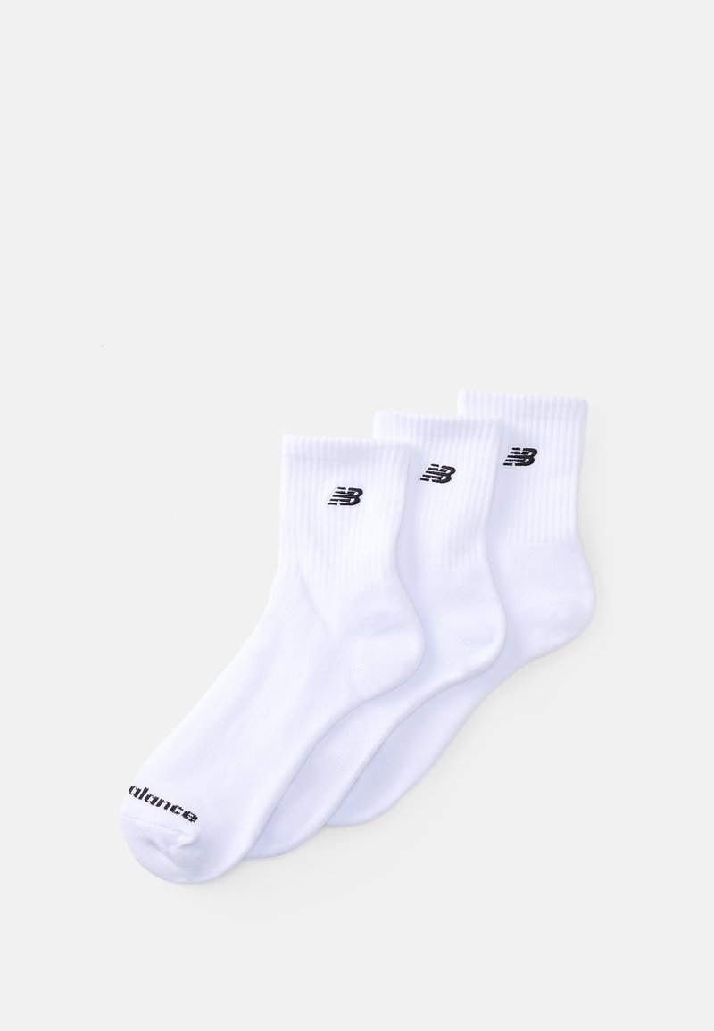 Trois paires de chaussettes de sport blanches avec une texture côtelée, présentant le logo "NB" noir et le nom de la marque imprimés sur les semelles.