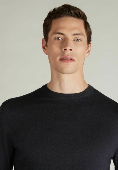 Czarny dziewiżany sweter z okrągłym dekoltem. Charakteryzuje się gładką fakturą i dopasowanym krojem, podkreślającym sylwetkę noszącej osobie.