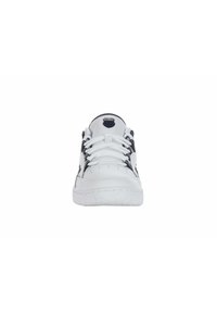 White sports shoes with a smooth leather upper, black accents, flat laces, and a textured rubber sole. Features logo on tongue.