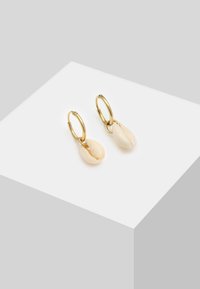Guld hoop øreringe med hvide muslingpendanter, der har en tekstureret overflade og en naturlig deling, hvilket skaber en unik designdetalje.