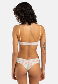 Blomsterbikini sett med lys blå bakgrunn, rosa og oransje blomster, tynne stropper og sømløst design.