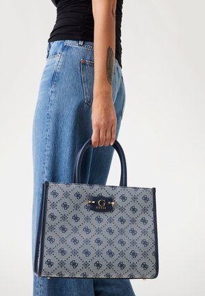 Navy blue handbag with a patterned canvas exterior and structured design. Features a smooth handle and a gold-tone clasp with logo detail.