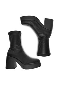 Czarne skórzane botki za kostkę z luźnym cholewką, grubym słupkowym obcasem i platformą. Gładka tekstura z minimalnymi detalami szycia.