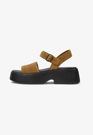 Brown suede platform sandals with a wide toe strap, adjustable ankle strap, and a black rubber sole. Features a buckle accent.