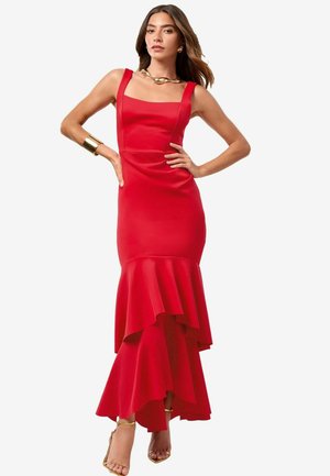 Red mermaid dress with a fitted bodice, square neckline, and layered ruffles at the hem. Made of smooth fabric with minimal embellishments.