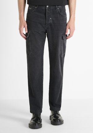 Zwarte denim cargobroek met een rechte snit, twee zijzakken en een licht vervaagde textuur. Gedirigeerd met zwarte veterschoenen.
