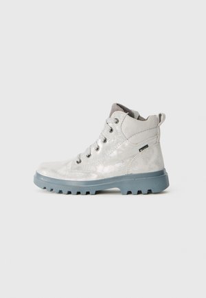 Botas de tobillo plateadas con un acabado brillante, suela de goma gris, cierre con cordones y un cuello acolchado para mayor comodidad. Incluye una característica de diseño impermeable.