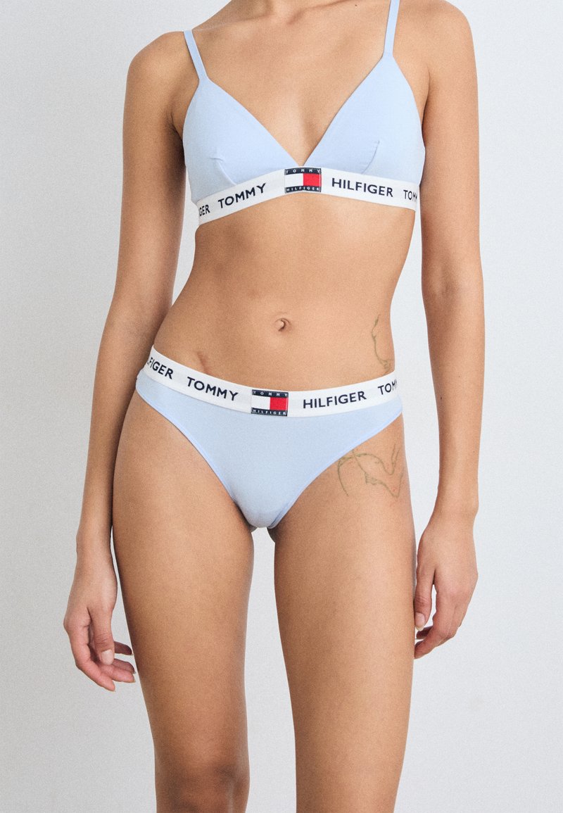 Soutien-gorge triangle bleu clair et thong assorti avec une bande blanche arborant le logo "TOMMY HILFIGER". Tissu doux, coutures minimales et design simple.