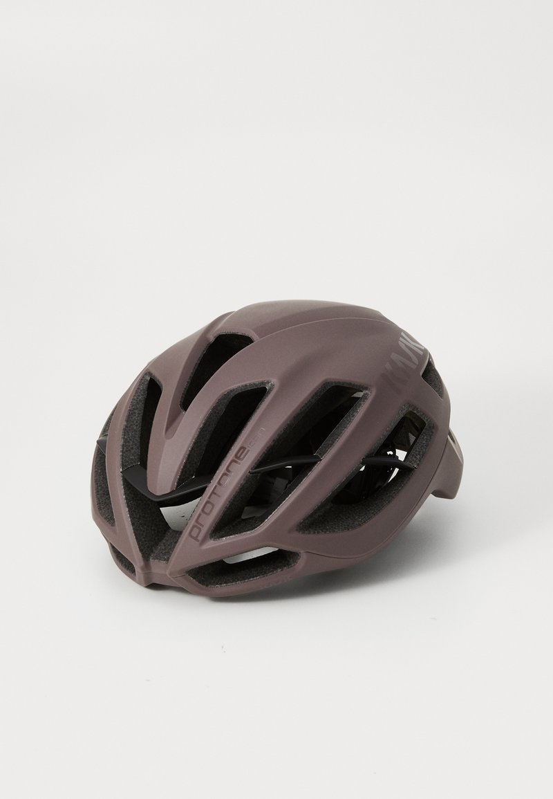 Kask rowerowy w matowym mauve, z wentylowanym designem, gładką powierzchnią i regulowanymi paskami. Posiada wyraźny napis po boku.