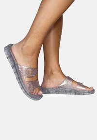 Sandales à glissière pailletées en transparent rose et gris avec deux sangles ajustables et une semelle texturée pour l'adhérence. Design ouvert à l'avant.