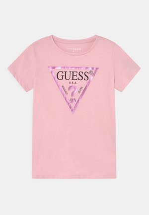 Hellrosafarbenes kurzärmeliges T-Shirt mit einem metallic-rosafarbenen Dreieck und schwarzem Text „GUESS U.S.A.“ und „Washed Jeans“ auf der Vorderseite.