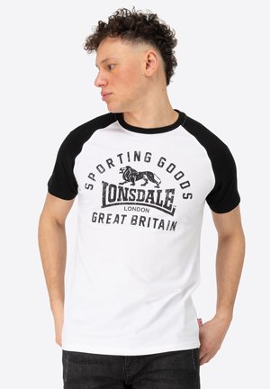 White and black raglan t-shirt features a graphic print with "Lonsdale London" and "Sporting Goods" details. Short sleeves, cotton fabric.