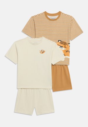 Dwa zestawy dziecięcych piżam z krótkim rękawem; jeden beżowy z małą twarzą tygrysa na piersi, drugi brązowo-biały w paski z dużą grafiką tygrysa na koszulce.