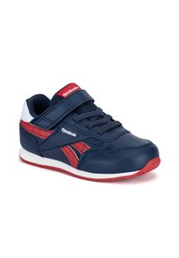 Deportiva para niños Reebok en azul marino y rojo con tira de Velcro, cordones, malla transpirable y suela blanca con huella roja.
