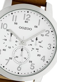 Round silver stainless steel watch with a white dial. Features black hour markers, three sub-dials, and a brown leather strap.