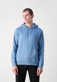Sweatshirt azul claro feito de tecido suave, apresentando um bolso frontal tipo canguru, cordão ajustável e um pequeno detalhe de logo no peito.