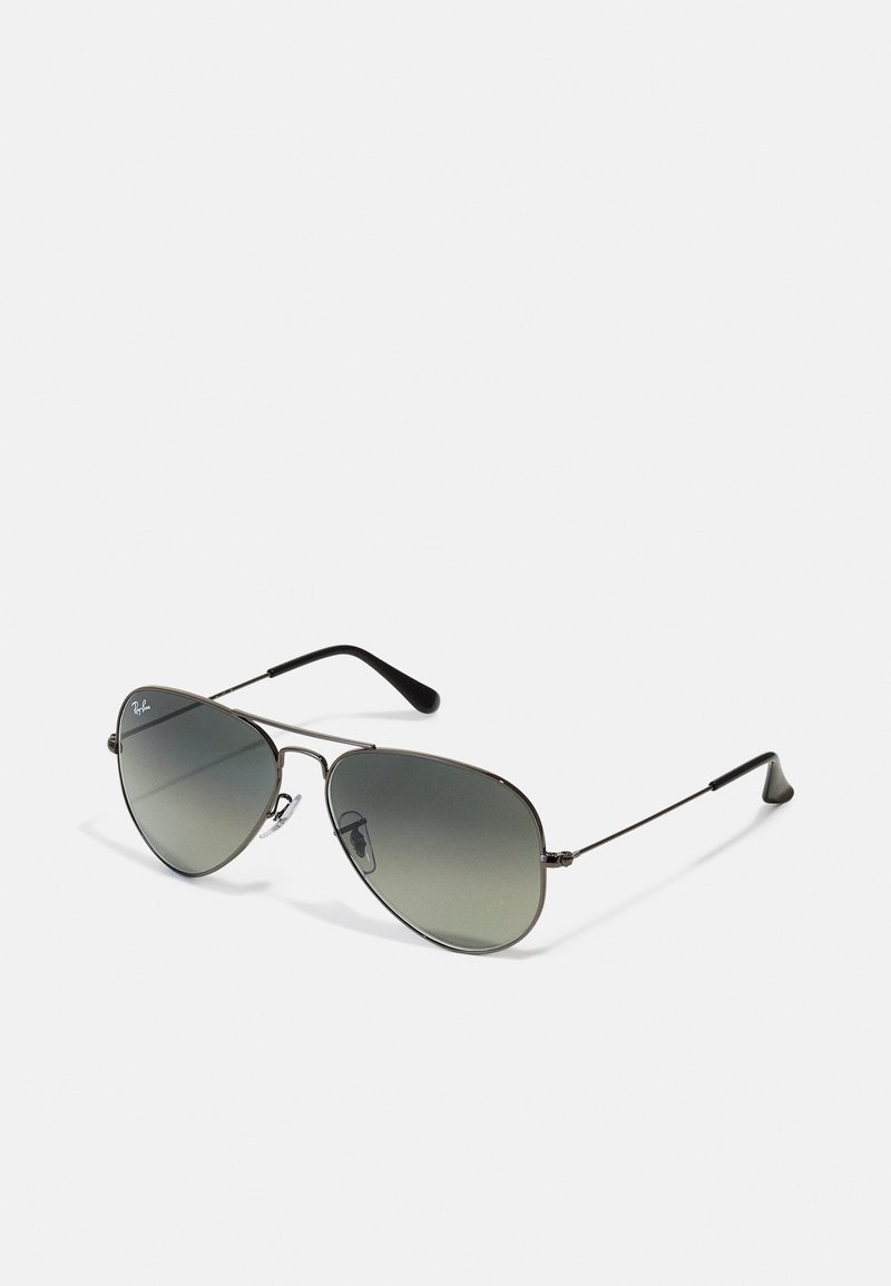 Ochelari de soare aviator cu un cadru metalic închis, lentile cu gradient gri și vârfuri negre la rame. Caracteristici includ un pod dublu și tampoane nazale ajustabile.