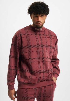 Maroon sweatshirt with black plaid pattern, ribbed cuffs and hem, and a "Thug Life" text detail on the collar. Soft, textured fabric.