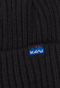 Svart strikket lue med et teksturert mønster og et KAVU-logo merkelapp som viser blå fjell og en rød prikk.
