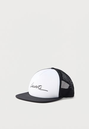 Gorra de camionero en blanco y negro con parte trasera de malla negra y un texto en cursiva negro en el panel frontal blanco.