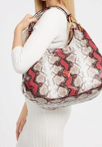 Grand sac hobo au design serpent, avec des nuances de blanc, marron et rouge. Texture lisse avec des accents dorés et des détails de logo.