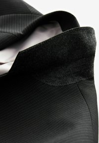 Czarna marynarka w paski z wyraźnym krawatem z filcowego materiału, z gładką podszewką i dopasowanymi detalami.