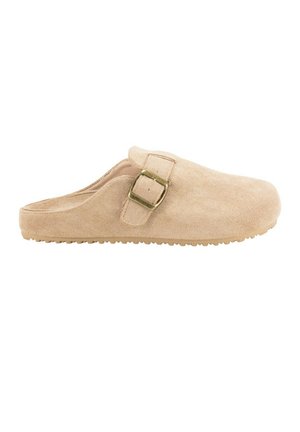 Zapato beige de ante tipo slip-on con punta redondeada, correa lateral con hebilla y suela texturizada para mayor adherencia. Material suave con acabado liso y diseño minimalista.