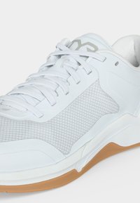 Άσπρο αθλητικό παπούτσι με πλευρικό πάνελ από δίχτυ, επενδυμένο κολάρο, κλείσιμο με κορδόνια και σόλα από καουτσούκ χρώματος τσίχλας.