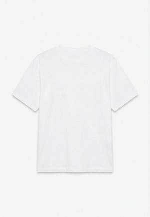 Απλό λευκό κοντομάνικο t-shirt με στρογγυλή λαιμόκοψη, απλωμένο επίπεδα πάνω σε λευκό φόντο.