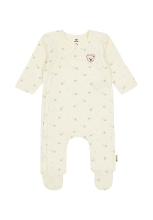 Babystrampler in Cremefarbe mit langen Ärmeln, Füßen, kleinem grünem Kleeblattmuster und einem kleinen Teddybär-Patch auf der Brust.