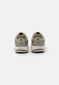 Baskets de sport grises et olive avec une tige en maille texturée, un col rembourré et une semelle blanche contrastante ; présente le logo Adidas au talon.