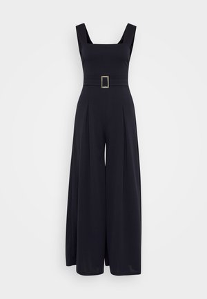 Mono negro con escote cuadrado, diseño de pierna ancha y cintura ceñida con cinturón que presenta una hebilla cuadrada. Fabricado en tejido suave.