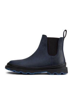 Navy blue leather Chelsea boot with black elastic side panels, pull tab at heel, and black sole with blue tread details.