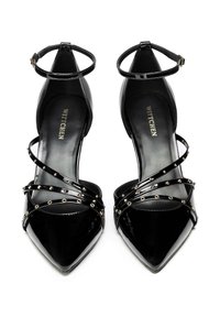 Eleganti scarpe con tacco alto in pelle verniciata nera, con punte appuntite e cinturini alla caviglia. Presentano cinturini incrociati decorati con borchie in tonalità oro per un tocco di stile.