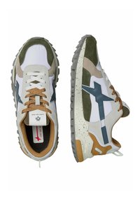 Sneakers caratterizzati da un mix di sintetico bianco e camoscio, accenti verdi, una suola in gomma grigia, lacci marroni e un motivo unico sulla suola intermedia.