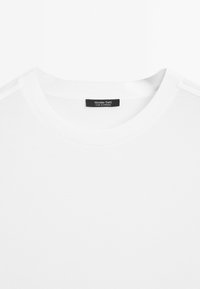 Weißes Kurzarm-T-Shirt mit Rundhalsausschnitt. Glattes Baumwollgewebe. Ein Etikett im Halsausschnitt ist sichtbar und trägt die Aufschrift "Massimo Dutti."