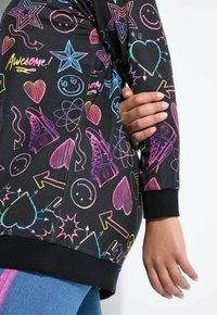 Felpa nera con stampe grafiche colorate e neon che includono stelle, cuori, faccine sorridenti e sneakers. Polsini a maniche e vestibilità comoda.