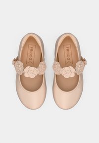 Chaussures Mary Jane en cuir rose pâle avec des accents floraux sur la bride et un design à bout arrondi. Texture douce et semelle plate.