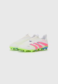 Botas de fútbol blancas con acentos en rosa y verde. Presentan un diseño aerodinámico, parte superior texturizada para el agarre y tachuelas coloridas para la tracción.