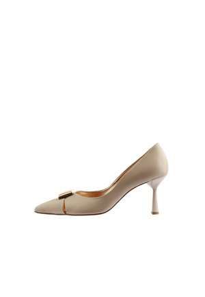 Chaussure à talon haut beige à bout pointu avec un petit détail de boucle dorée et un talon stiletto fin, vue de profil sur fond blanc.