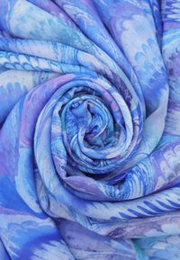 Sciarpa leggera in diverse tonalità di blu, con motivi intricati. Il tessuto ha una consistenza morbida e un drappeggio elegante.
