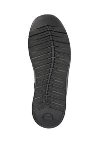 Semelle de chaussure noire avec un motif de semelle pour traction ; présente des rainures et segments allongés ; comprend un logo circulaire au niveau du talon.