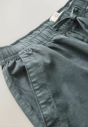 Graue Stoffshorts mit einem elastischen Bund, Kordelzug und genähten Details an der Seite. Glatte Textur und lässiges Design.