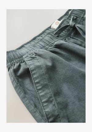 Szare szorty z materiału z elastycznym pasem, sznurkiem do regulacji i przeszyciami po bokach. Gładka tekstura i casualowy design.