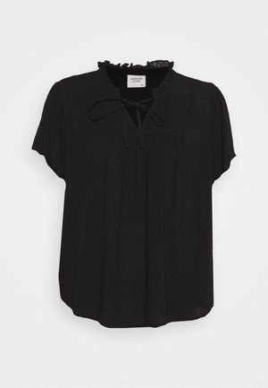 Blouse noire à manches courtes avec un col volanté et un détail à nouer. Le tissu présente un motif texturé subtil de petits points.