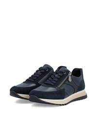 Paire de baskets sportives bleu foncé avec lacets, fermeture éclair latérale et semelles blanches, présentée sous un léger angle sur fond blanc.