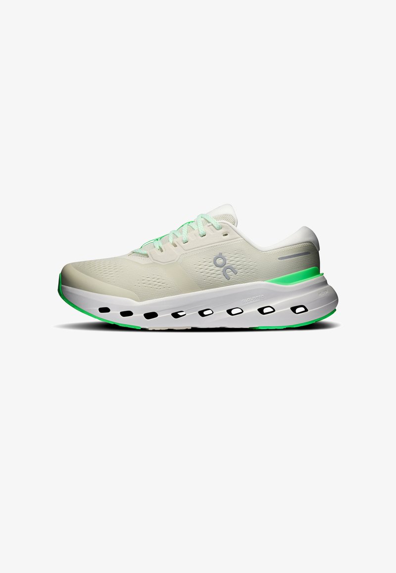Chaussure de course blanche avec des accents verts, semelle amortissante perforée et fermeture à lacets. Logo latéral visible. Fond blanc uni.